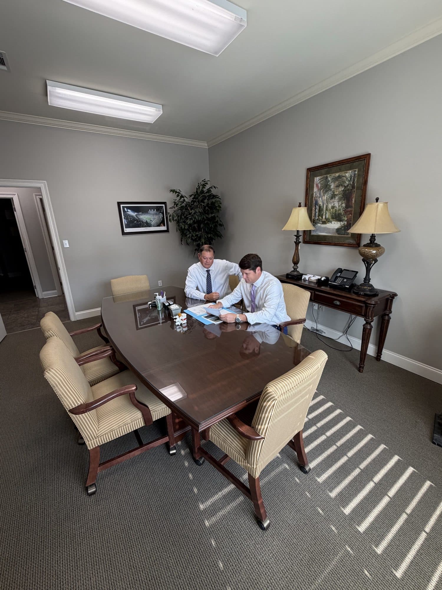Erik Tadda and Rick Tadda reviewing a file together at the conference table in the firm’s Baton Rouge office