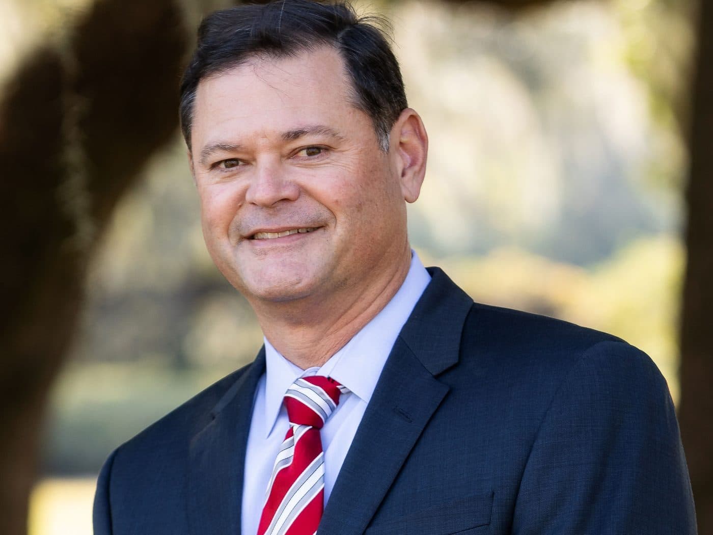 Attorney Erik Tadda of The Tadda Law Firm outdoors under live oaks
