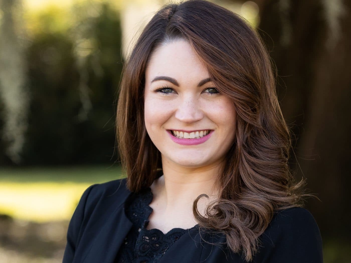 Attorney Sarah Tormey of The Tadda Law Firm outdoors under live oaks