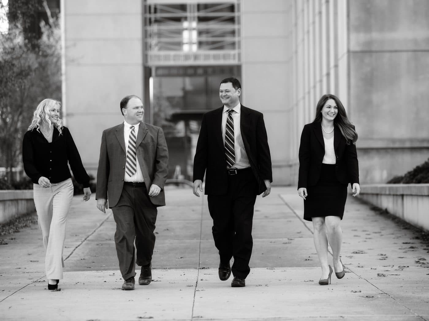 Members of The Tadda Law Firm walking together outdoors, in black and white
