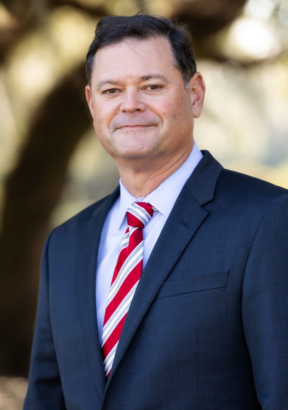 Attorney Erik Tadda of The Tadda Law Firm outdoors under live oaks